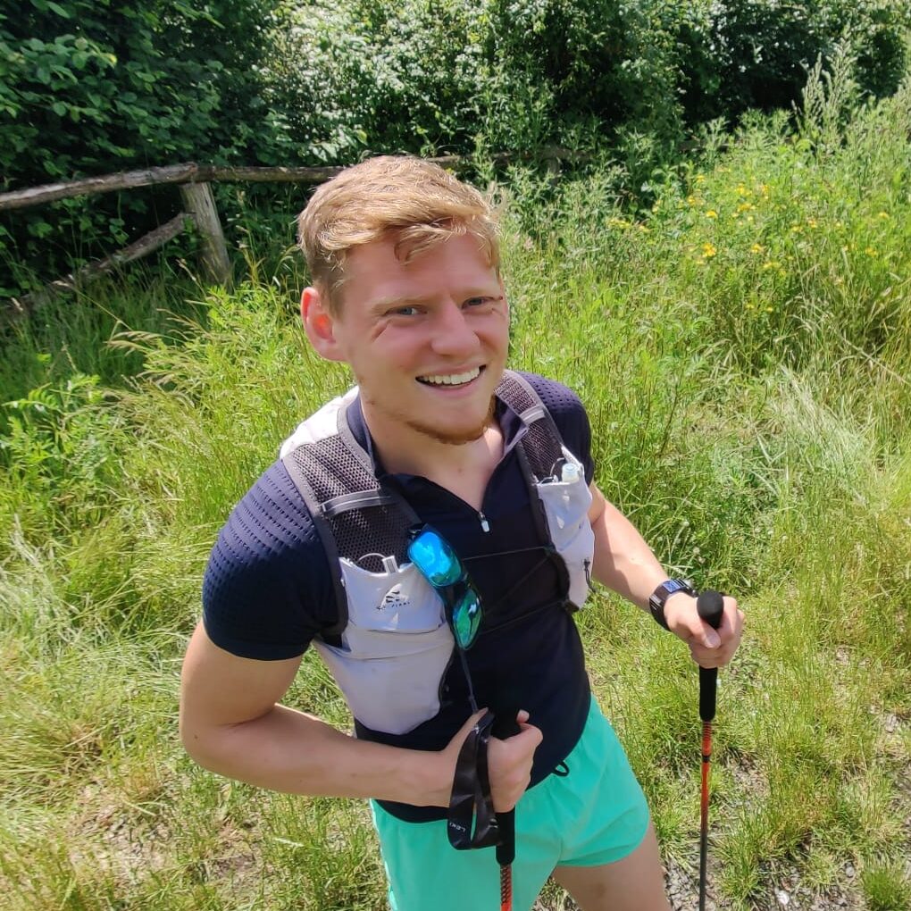 Stefan in voller Trail-Runner-Montur auf einer Wiese